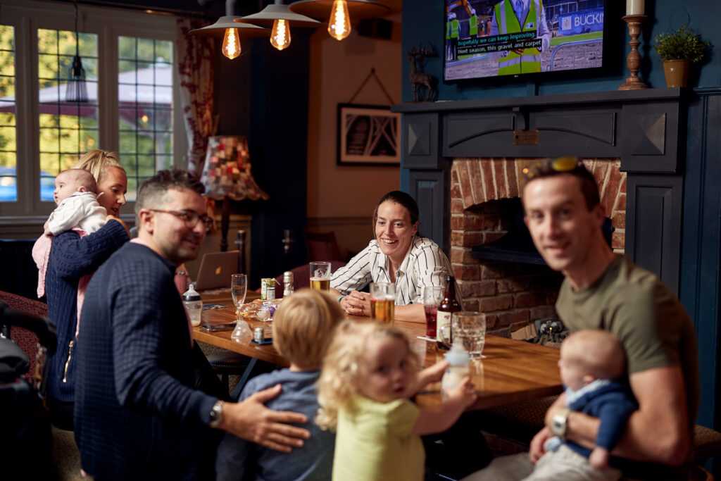 A family is sitting around a table, looking happy to be together.