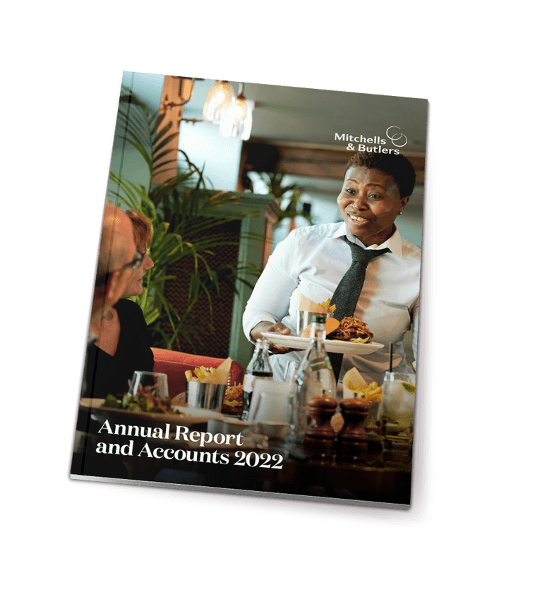 The Mitchells & Butlers' Annual Report and Accounts 2022 is set against a white background. On its cover, a team member smiles while serving food to a guest.