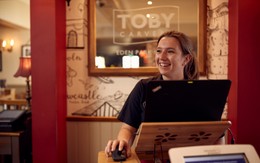 A team member at Toby Carvery stands smiling, ready to greet guests at the door.