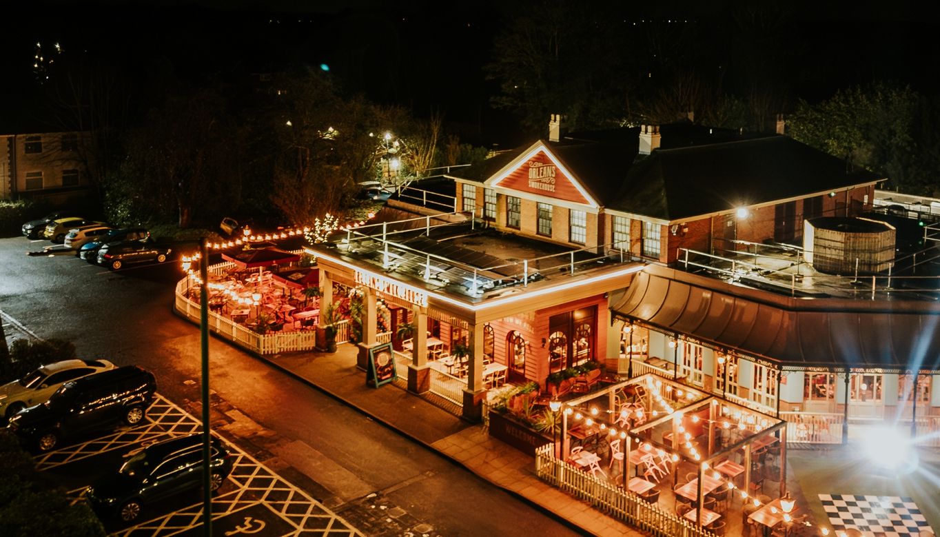 An external shot of the restaurant's exterior, at night time. The building has a warm glow from all the lights up around it.