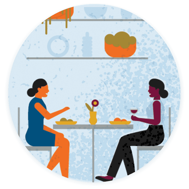 Two people are having a conversation over food and drinks.